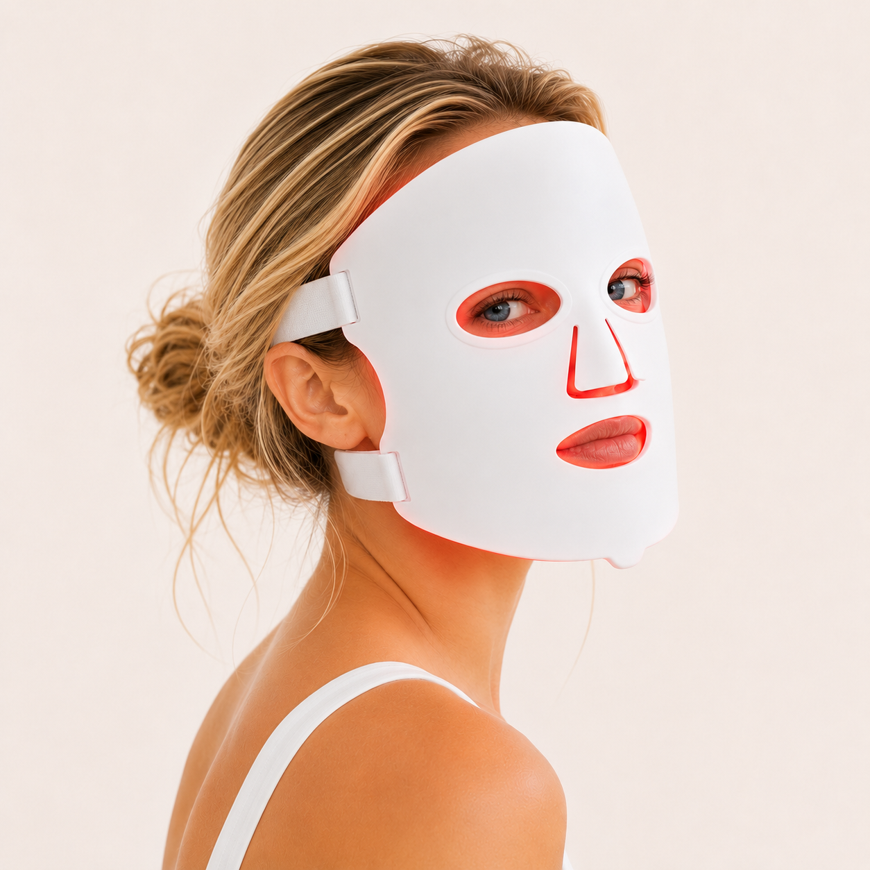 Woman using the AuraFace LED red light therapy face mask, front view